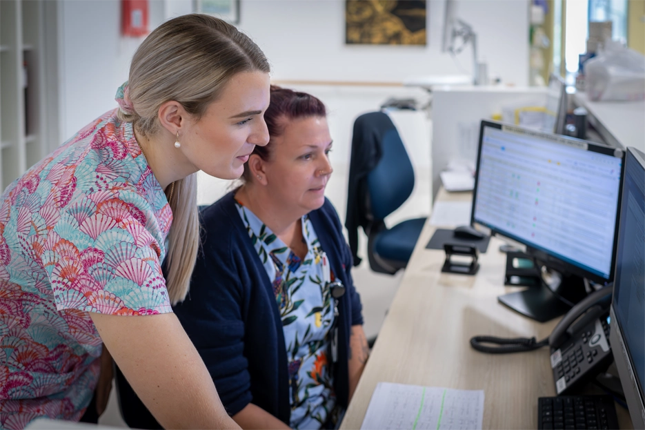 Two clinicians looking at a computer screen
