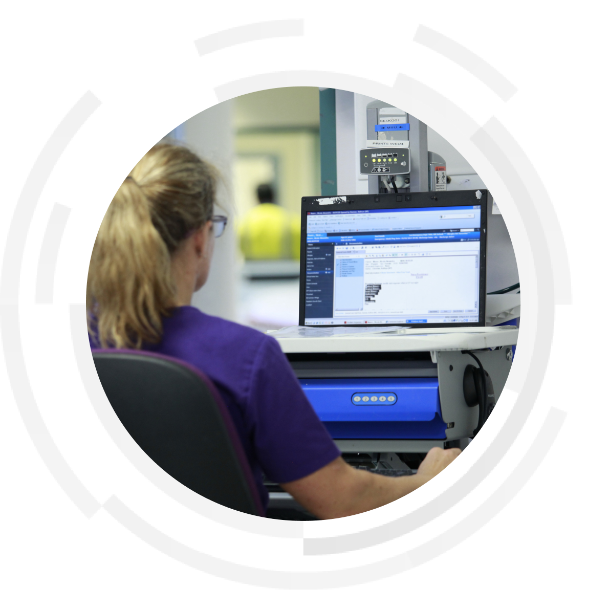 Female nurse sitting down using desktop computer.