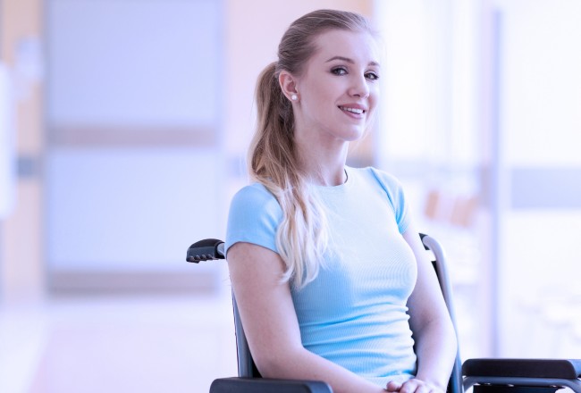 A young woman sits in a wheelchair in a medical environment