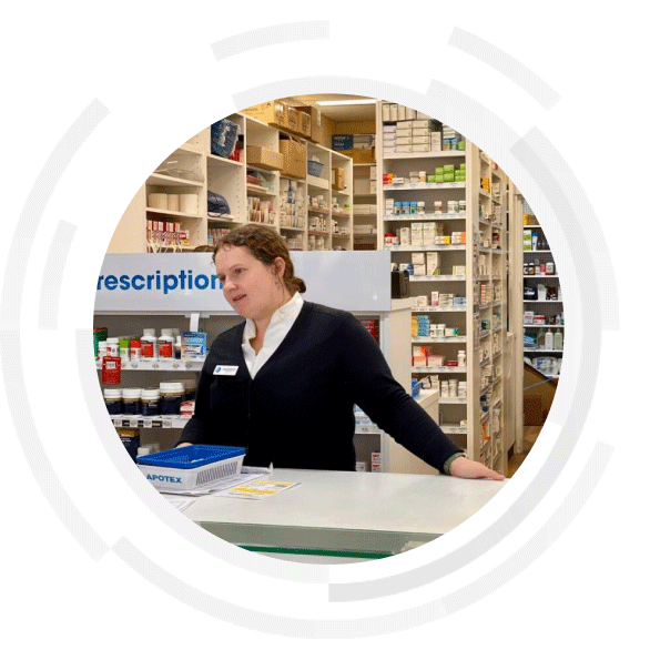 Female pharmacist standing behind the counter with a customer