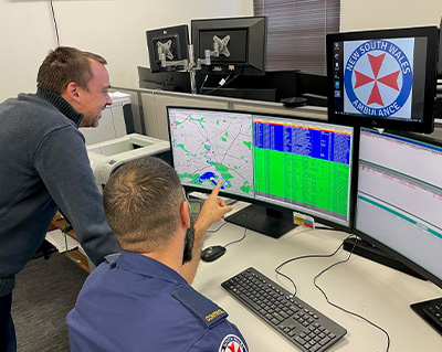 Lachlan House (standing) and Darren James during testing of the VisiCAD changes to support Advanced Mobile Location (AML) data from the Telstra Emergency Triple Zero (000) service.