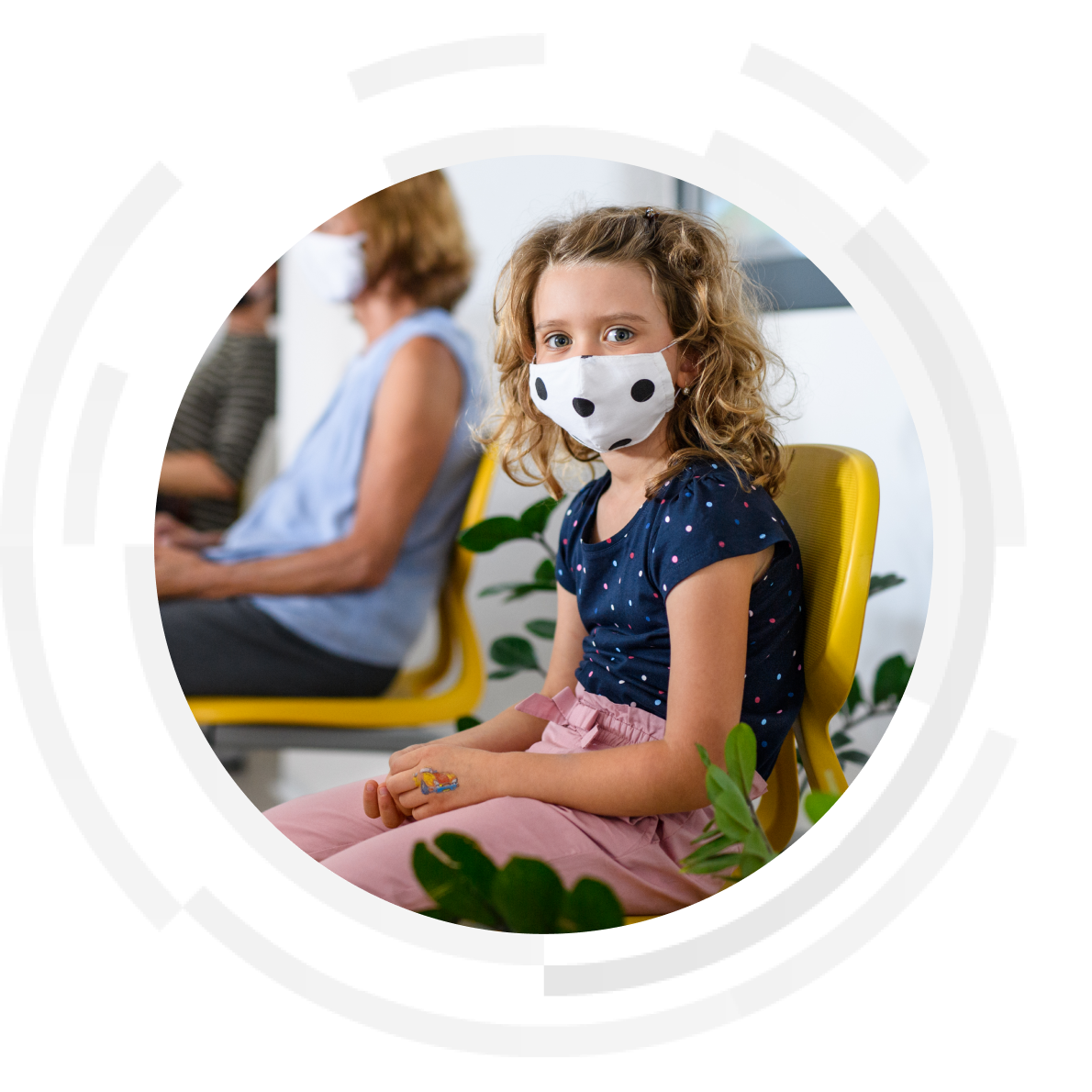 Young female child wearing mask in hospital waiting room.