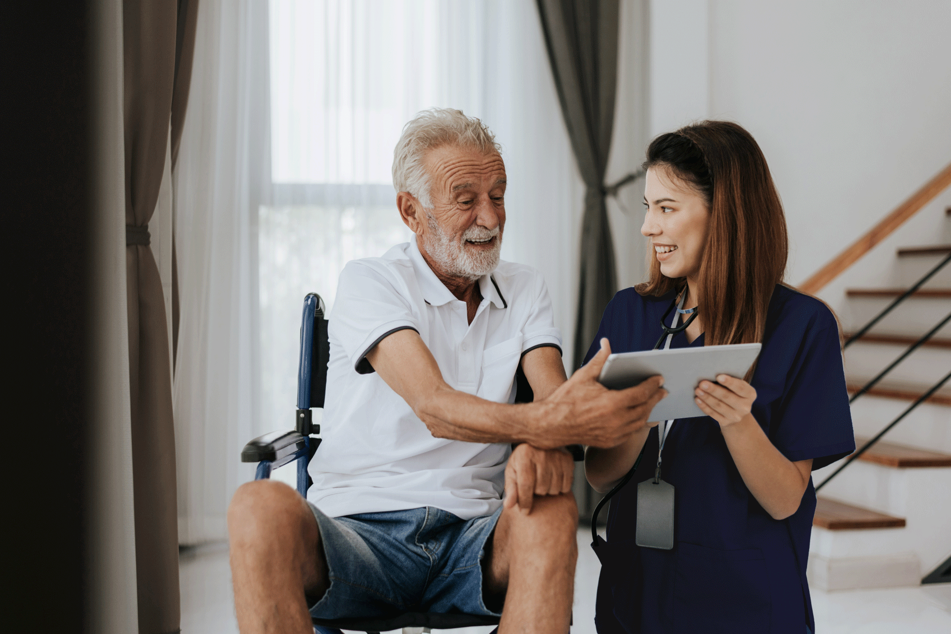 Female nurse showing elderly man a tablet.
