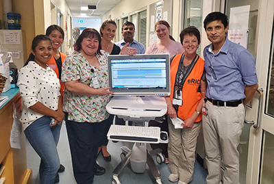 Staff standing with workstation on wheels in hospital using the eRIC program