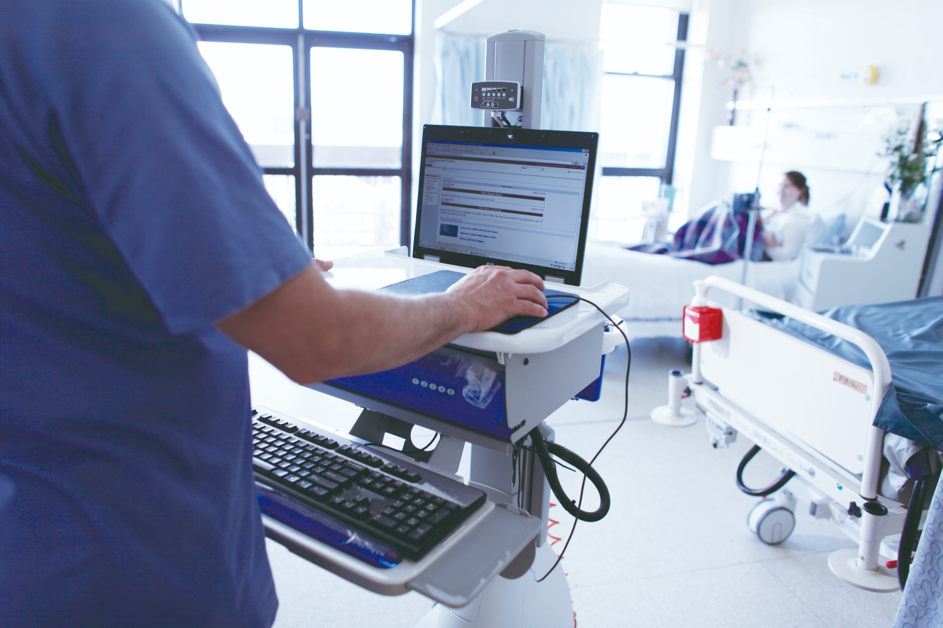 Nurse entering patient data on a computer.