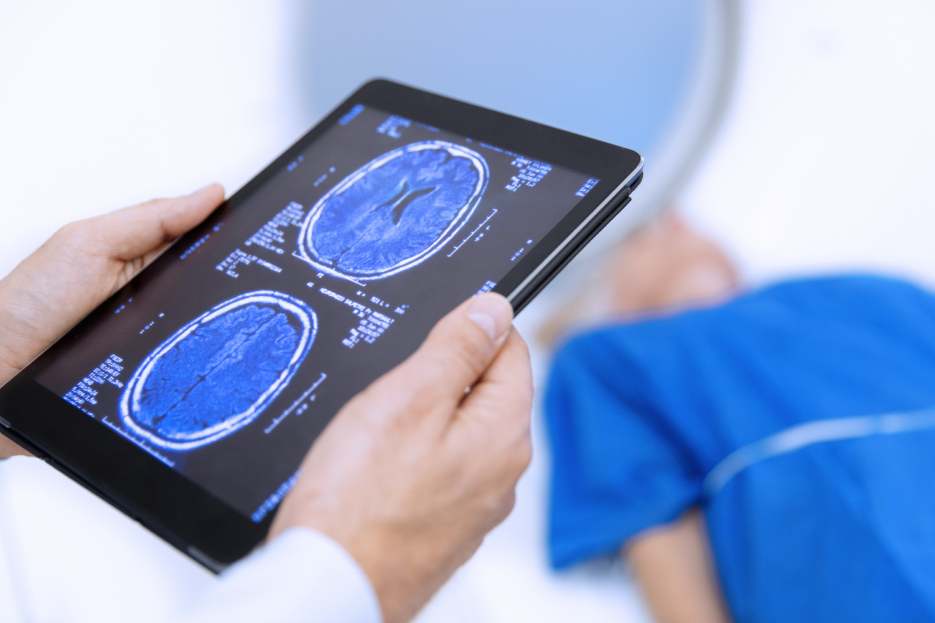 Clinical holding a tablet displaying medical imagery