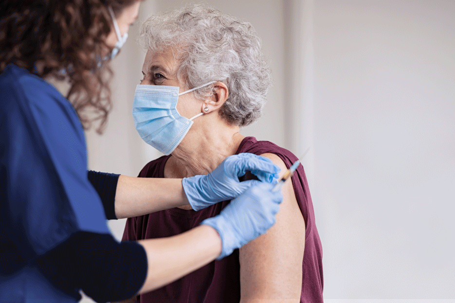 Clinician administering a vaccination for an elderly woman