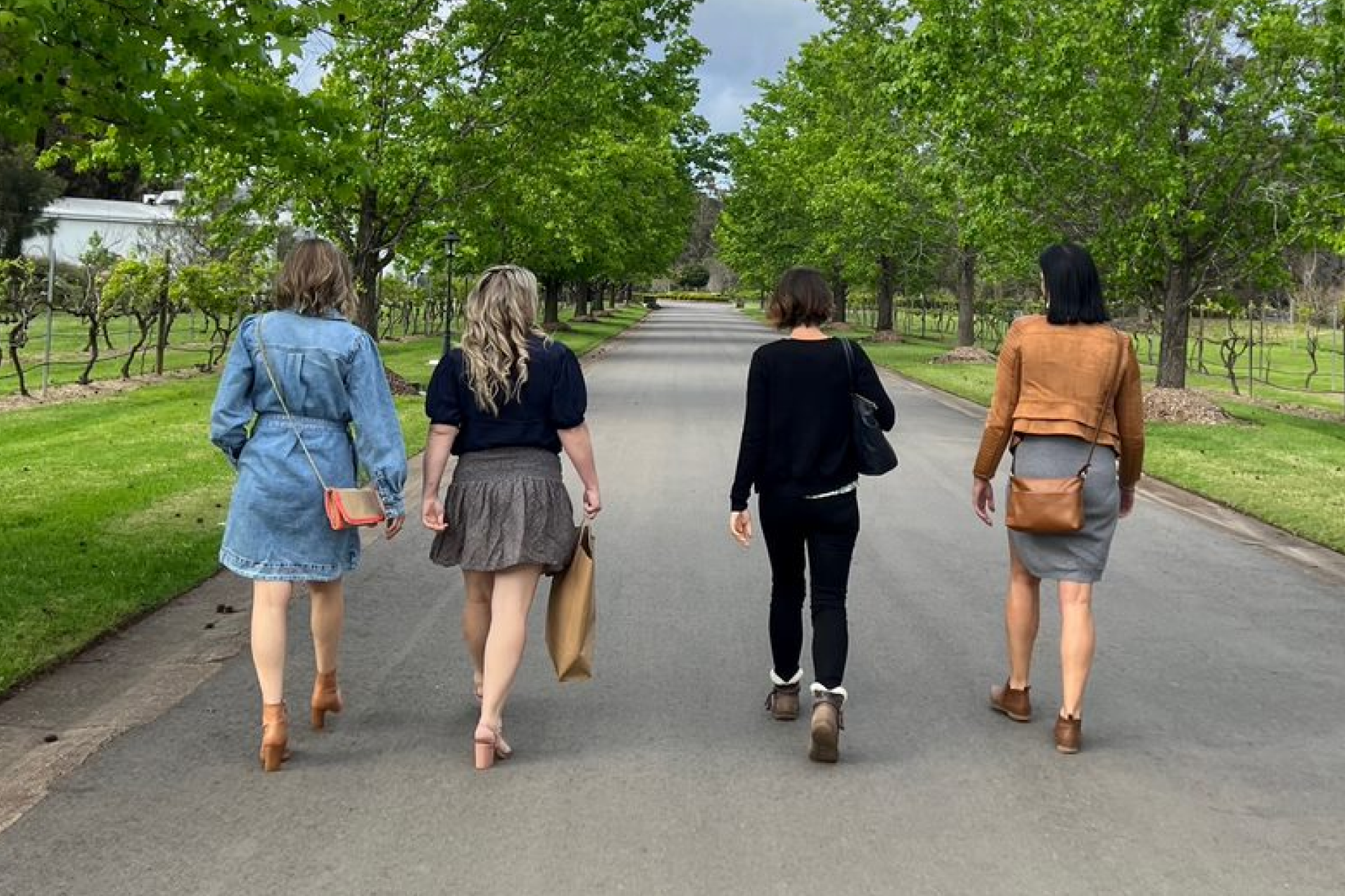 Four women walking along a wide path