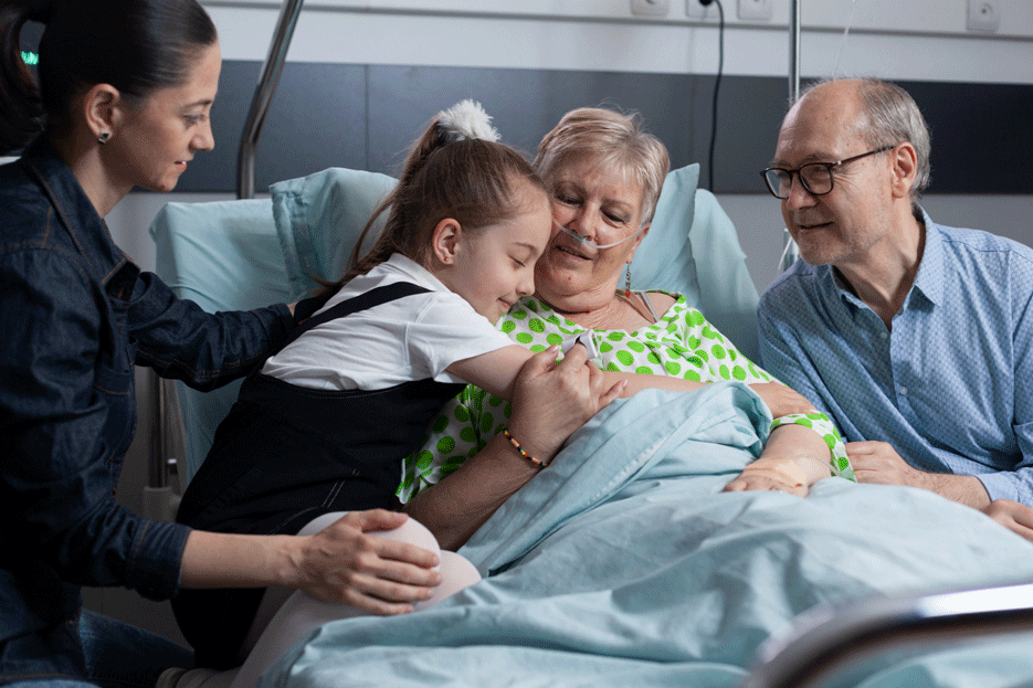 Family hugging around a hospital bed
