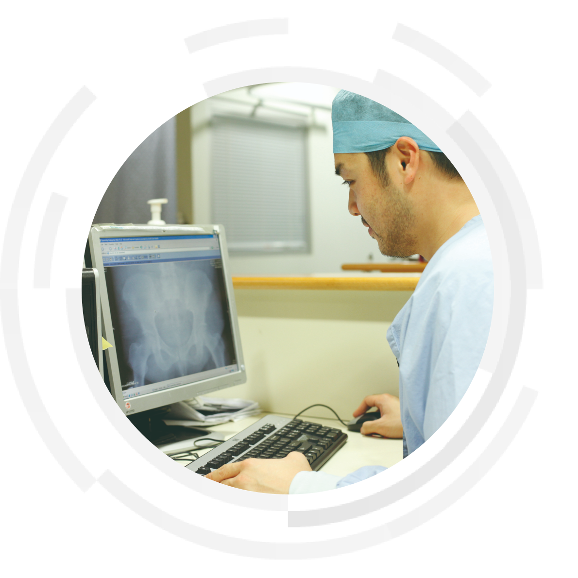 Doctor referencing patient medical records on a computer desktop.