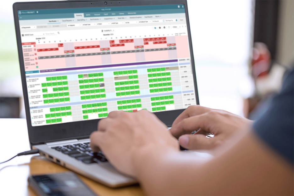 Male clinician working off laptop.